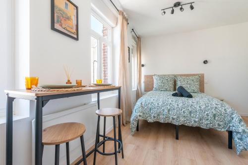 a bedroom with a bed and a table and stool at Casa 37 in Saint-Quentin