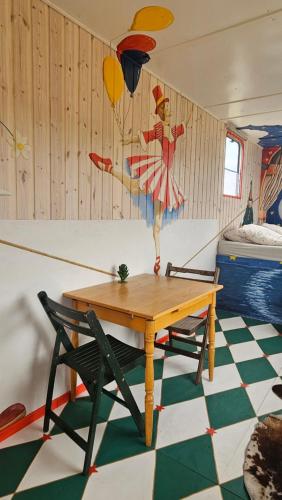 a room with a table and a painting on the wall at Benneweis in Brædstrup