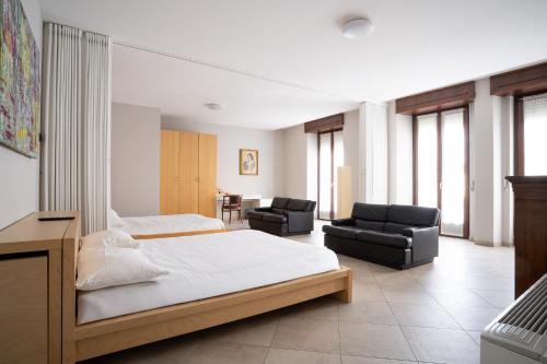 a bedroom with a bed and two chairs in it at Aparthotel All'Orologio in Peschiera del Garda