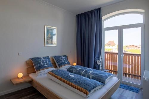 a bedroom with a bed with a large window at Heimathafen über dem Hafen - Pub in Pellworm