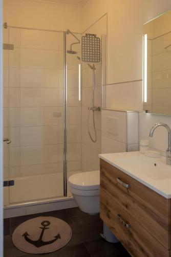 a bathroom with a shower and a toilet and a sink at Heimathafen über dem Hafen - Pub in Pellworm