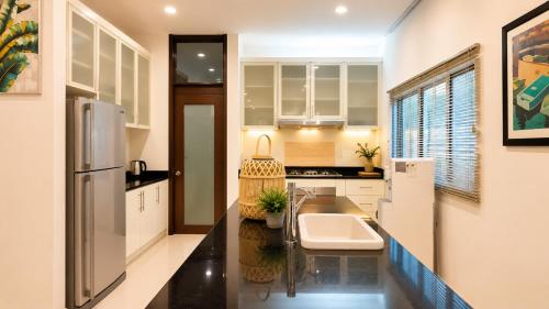 a kitchen with a sink and a refrigerator at Bungalow Perkasa in Kuala Lumpur