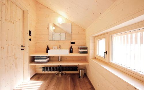 a bathroom in a log cabin with a sink and a window at CASALPIN Chalets in Brand