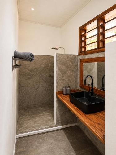 a bathroom with a sink and a shower at Maison le Rêve in Nosy Be