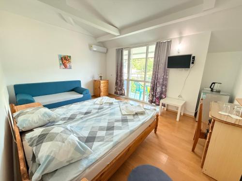 a bedroom with a large bed and a window at Guest House Orfey in Kranevo