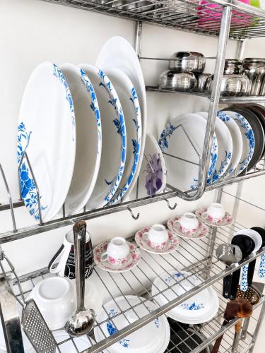 a shelf filled with plates and cups and dishes at Sai Mahima Stays in Shirdi