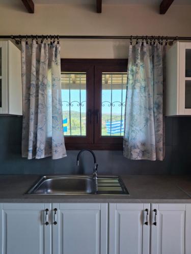 a kitchen with a sink and a window at Terra Solaris Guesthouse in Kissamos