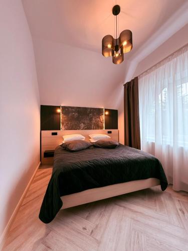 a bedroom with a large bed and a chandelier at Shiro Nord in Predeal
