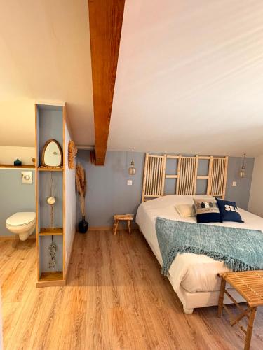 a bedroom with a bed and a toilet in it at Le Logis de la Gabirotte in Nieulle-sur-Seudre