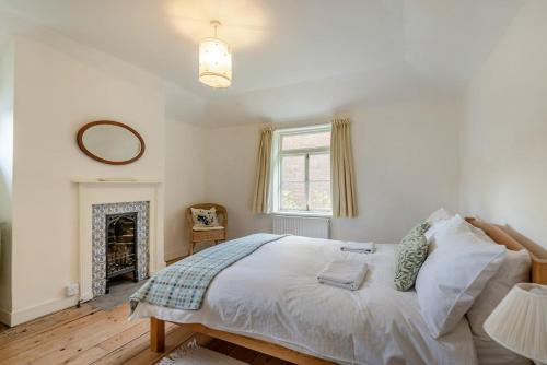 a bedroom with a large bed and a fireplace at 4 Bed in Lyndhurst oc-57407 in Lyndhurst
