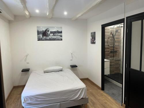 a white room with a bed and a bathroom at Appartement Limoges in Limoges