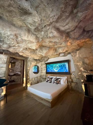 a bedroom with a bed in a rock wall at EmmejSuite in Pozzuoli