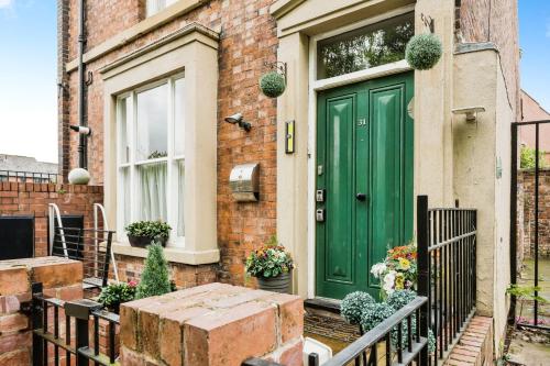 a green door on the side of a brick house at Chester Apartments in Chester