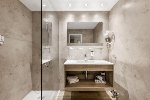 a bathroom with a sink and a glass shower at Haags Hotel Niedersachsenhof in Verden