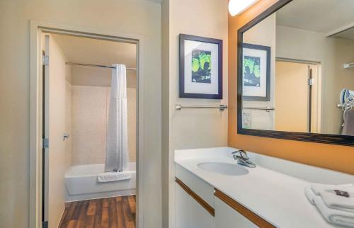a bathroom with a sink and a mirror and a tub at Extended Stay America Select Suites - Chicago - Lombard - Oakbrook in Oakbrook Terrace