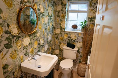 a bathroom with a sink and a toilet and a mirror at Ivy House in Stockbridge