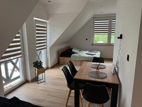 a room with a table and a bed and a bedroom at Kontrabanda - Bar & Noclegi in Ustrzyki Górne