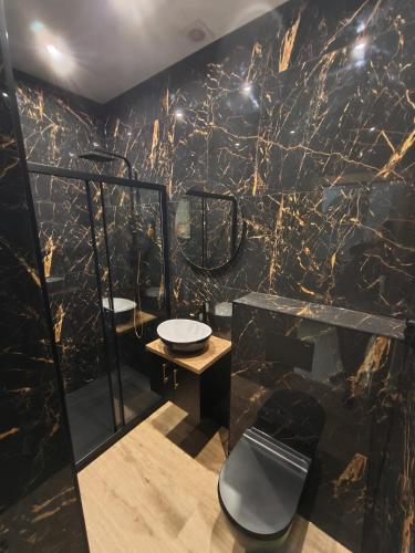 a bathroom with two sinks and a marble wall at Kontrabanda - Bar & Noclegi in Ustrzyki Górne