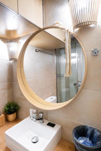 a bathroom with a round mirror above a sink at En Lefko Boutique Apartments in Nikiana
