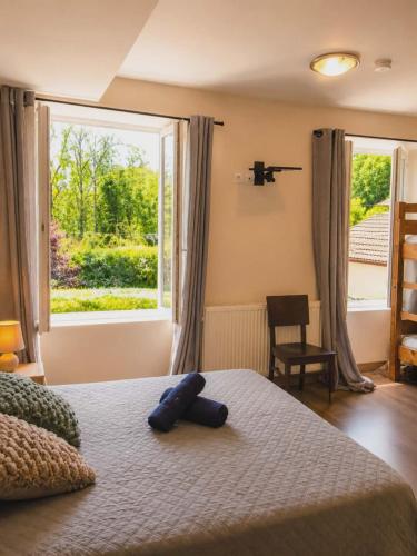 a bedroom with a bed and a large window at La Diligence in Lepin-le-Lac