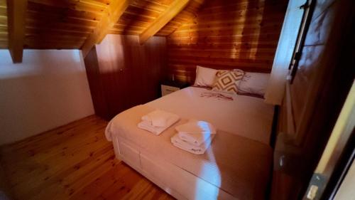 a small room with a bed with towels on it at Mountain Attic Near Përmet in Biovizhdë