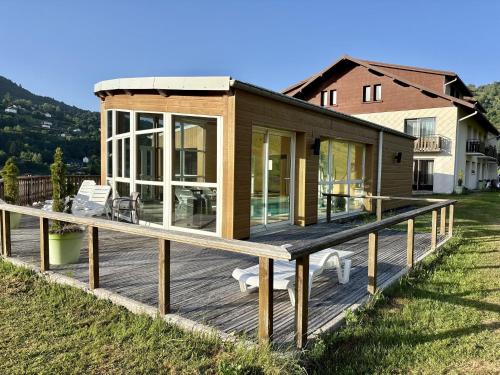 a house with a large deck and a house at Hôtel Restaurant & Bien-être Le Chalet des Roches in La Bresse
