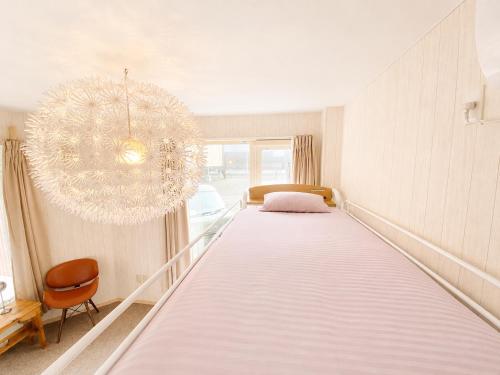 a large bed in a room with a chandelier at Yume House in Furano