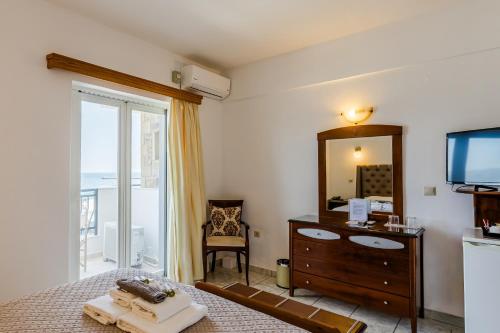 a bedroom with a bed and a mirror and a tv at Filoxenia Hotel Monemvasia in Monemvasia