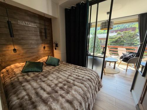 a bedroom with a bed with two green pillows at Mimi lodge familly in Valloire