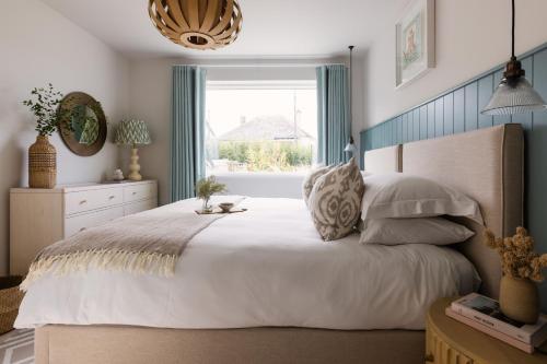 a bedroom with a large bed with a window at Brennik House in Port Isaac
