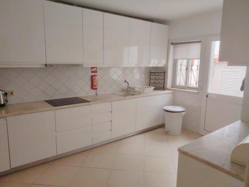 a white kitchen with white cabinets and a window at Vale Do Lobo 935 in Loulé