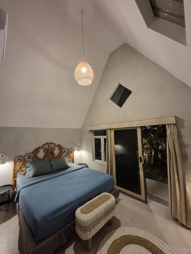 a bedroom with a blue bed and a chair at Mulyanus Hotel by Calli Rooms in Wirolegi