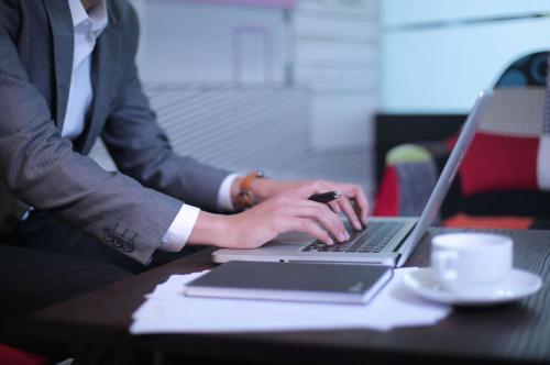 a man in a suit typing on a laptop computer at favehotel Margonda in Depok