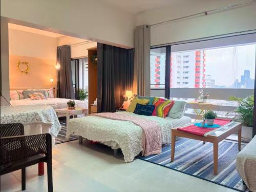 a bedroom with a bed and a couch and a table at Cozy 1br walk to BTS and Airport Rail Link Close to Malls T in Bangkok