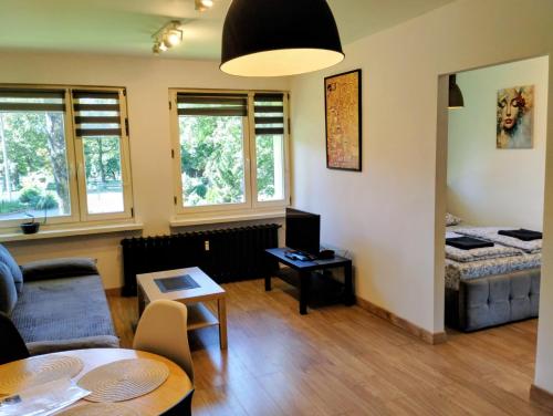 a living room with a couch and a table at Park Redena Katowice/Chorzów in Chorzów