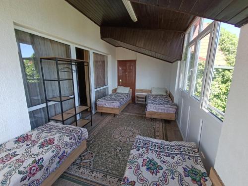 a room with three beds in a room with windows at Любимый in Cholpon-Ata