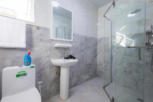 a white bathroom with a sink and a shower at SereneKey Stays in Kigo