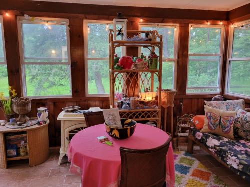 a room with a table with a pink table cloth at Wine and roses farm house in Waymart