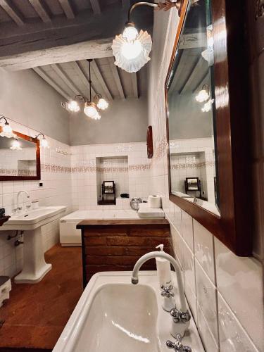 a bathroom with a tub and a sink and a mirror at Casa Amiata in Sarteano