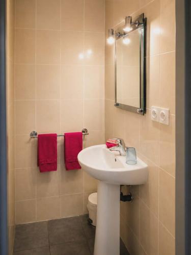 a bathroom with a sink and a toilet and a mirror at La Diligence in Lepin-le-Lac