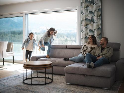 a group of people sitting on a couch in a living room at Panorama-Lodge Mittagskogel in Ledenitzen