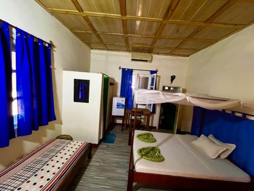 a room with two bunk beds and a table at Hotel Le Petit Paradis in Antsiranana