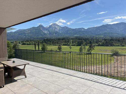 a patio with a table and a view of mountains at Panorama-Lodge Mittagskogel in Ledenitzen