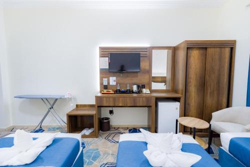 a room with two beds and a desk and a tv at فندق عصفور 03 in Mecca