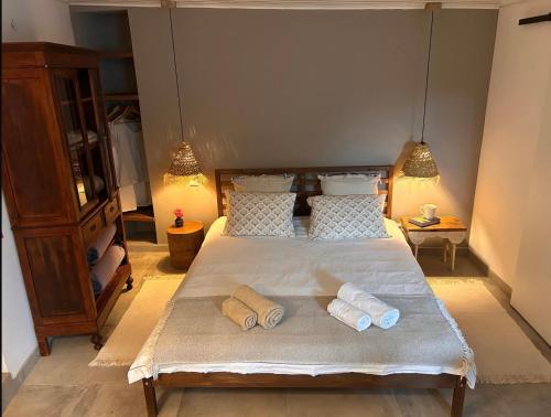 a bedroom with a bed with two towels on it at Pé na Praia in Torres Vedras