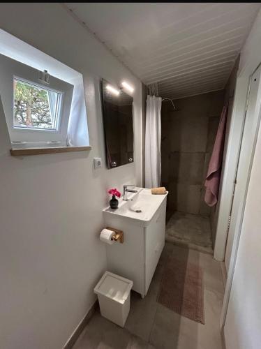 a white bathroom with a sink and a shower at Pé na Praia in Torres Vedras