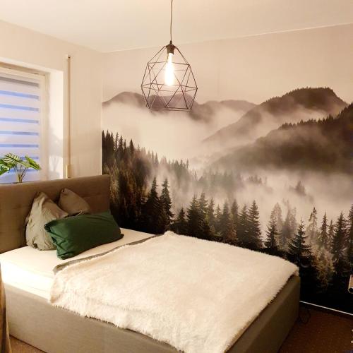 a bedroom with a bed with a mountain mural on the wall at Ferienwohnung Pension Zwethau in Beilrode