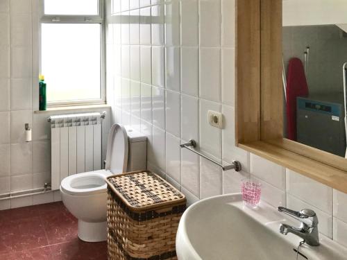 a white bathroom with a toilet and a sink at Apartagal- Casa Playa, Foz in Foz
