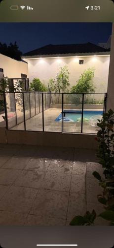 a fence in front of a swimming pool at night at شاليهات أفق in Jeddah