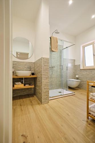a bathroom with a glass shower and a tub at RG MAISON - Room 35 in Morino